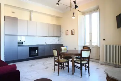 a kitchen and dining room with a table and chairs at Fontana Più Stella in Rome