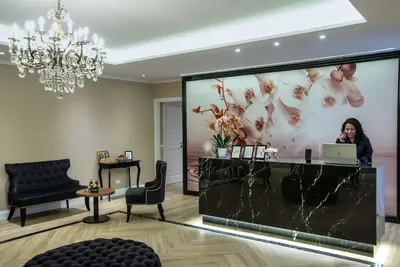 a woman sitting at a reception desk with a laptop at The Boutique Hotel in Rome