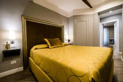 a bedroom with a large yellow bed with a large headboard at Hotel Antica Locanda in Rome