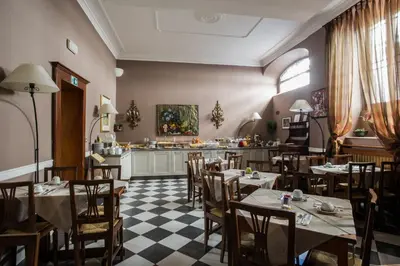 a restaurant with tables and chairs and a kitchen at Hotel Residenza In Farnese in Rome