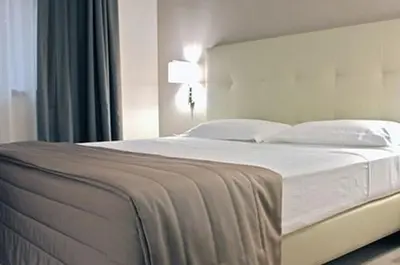 a bedroom with a large bed with white sheets and pillows at Hotel Desiderio in Rome