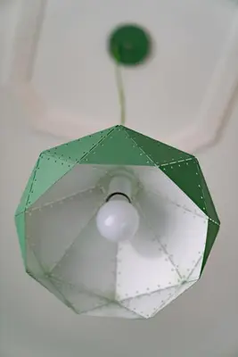 a green and white umbrella hanging from a ceiling at Merulana Star in Rome