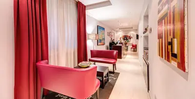 a living room with red chairs and a red curtain at Target Inn Rooms in Rome