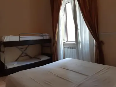 a bedroom with a bed and a window and a shelf at Hotel Aristotele in Rome