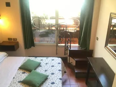 a bedroom with a bed and a view of a balcony at Hotel OKAPI in Rome