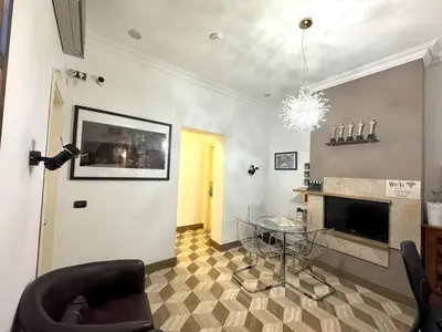a living room with a table and a fireplace at The Five Oscars Inn in Rome
