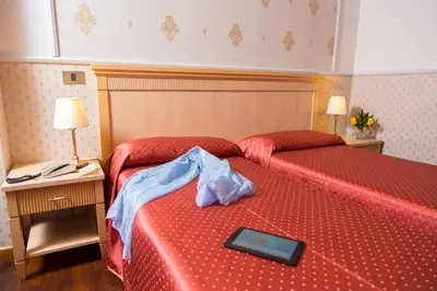 a hotel room with a red bed with a tray on it at Hotel Arco Di Travertino in Rome