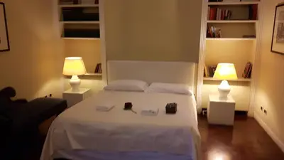 a bedroom with a white bed with two lamps at Giulio Caesar in Rome