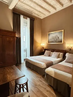 a hotel room with two beds and a table at Residenza Sciarra Suites in Rome