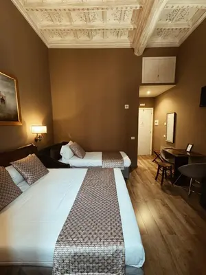 a hotel room with two beds and a table at Residenza Sciarra Suites in Rome