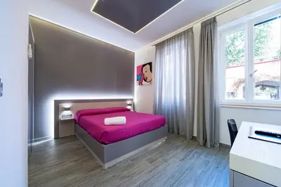 a bedroom with a bed with a pink blanket at Guesthouse Pop in Rome