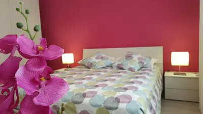 a bedroom with a bed with purple flowers at Casa di Angela in Rome