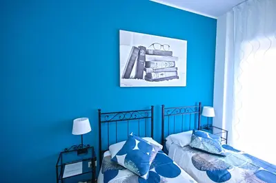 a blue bedroom with two beds with blue walls at Casa di Angela in Rome