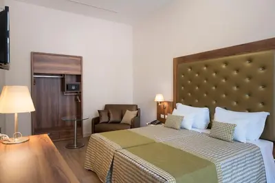a hotel room with a bed and a chair at Navona Luxury Guesthouse in Rome