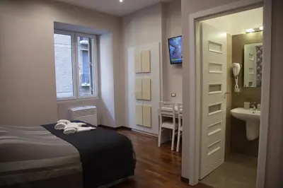 a bedroom with a bed and a sink and a bathroom at Maison Imperiale in Rome