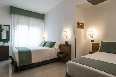 a hotel room with two beds and a window at Hotel Pacific in Rome