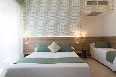 a bedroom with two beds and a mirror at Hotel Pacific in Rome