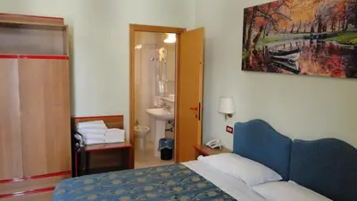 a bedroom with a bed and a bathroom with a sink at Hotel Altavilla Dieci in Rome