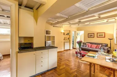 a kitchen and living room with a couch and a table at Trastevere Attic with Terrace in Rome