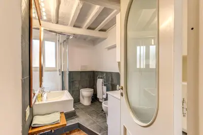 a bathroom with a sink and a toilet and a mirror at Trastevere Attic with Terrace in Rome
