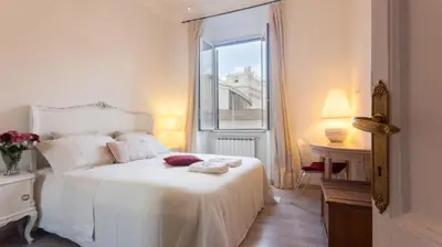 a white bed in a room with a window at Vatican View Apartment in Rome