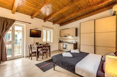 a bedroom with a bed and a kitchen with a table at Aurelia Vatican Apartments in Rome