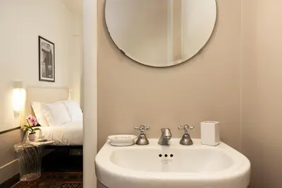 a bathroom with a sink and a mirror and a bed at Gatsby Guest House - Zen 60 in Rome