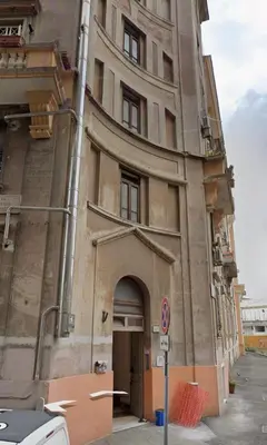 a tall building with an archway on a street at Green Rooms Trastevere in Rome