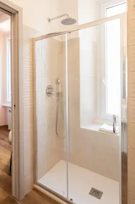 a shower with a glass door in a bathroom at Queen Meg Roma in Rome