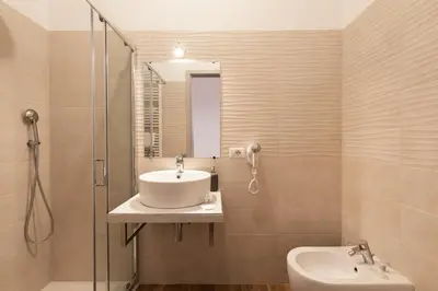 a bathroom with a sink and a glass shower at Queen Meg Roma in Rome