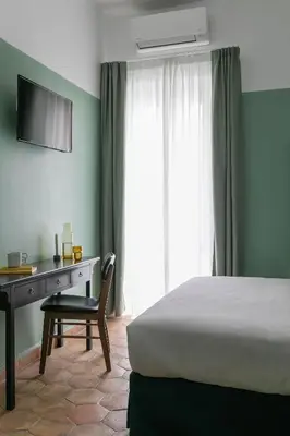 a bedroom with a bed and a desk and a television at UnoUnOtto in Rome