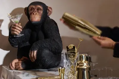 a monkey sitting on a table holding a drink at Borghese Contemporary Hotel in Rome
