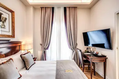 a hotel room with a bed and a desk with a television at Eitch Borromini Palazzo Pamphilj in Rome