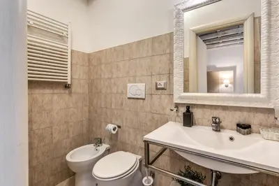 a bathroom with a toilet and a sink and a mirror at Magenta Deluxe Cancello in Rome