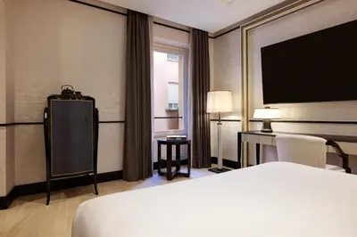 a hotel room with a bed and a flat screen tv at Nobu Hotel Roma in Rome