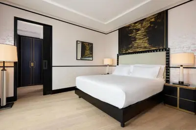 a bedroom with a large white bed and two lamps at Nobu Hotel Roma in Rome