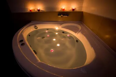 a large bath tub with candles in a bathroom at Luxury House Vaticano in Rome