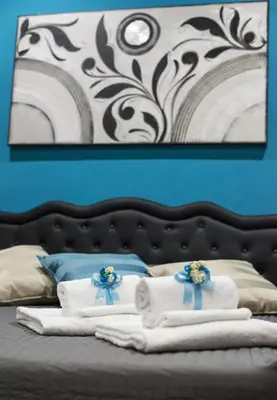 a pile of towels on a bed with a blue wall at Costantino Secondo Guest House in Rome