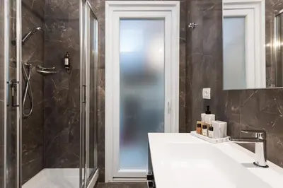 a bathroom with a shower and a sink and a mirror at Vatican Imperial Apartment 2840sq ft in Rome