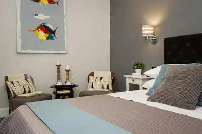 a bedroom with a bed and two chairs at Maison Boncompagni in Rome