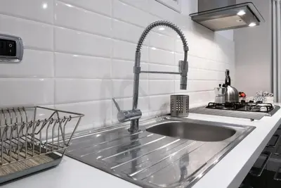 a stainless steel sink in a white kitchen at Maison Boncompagni in Rome