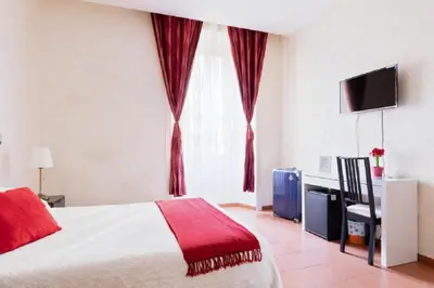 a bedroom with a bed with a red blanket at Roma Enrico Guesthouse in Rome
