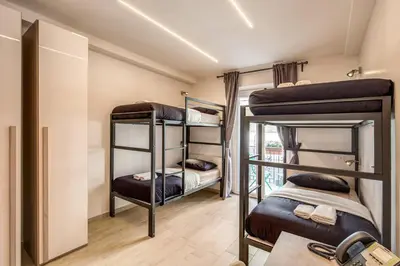 a room with three bunk beds and a table at The Bricks Rome in Rome