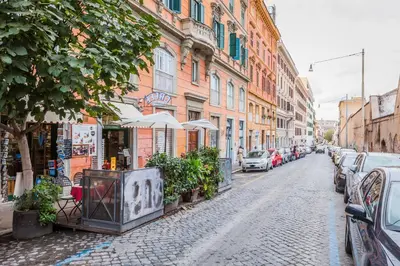 a cobblestone street with buildings and cars parked at Hotel 4 Coronati in Rome