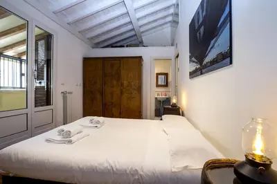 a bedroom with a large white bed and a window at Vatican Attic With Terrace in Rome