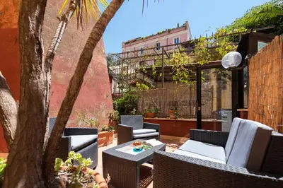 a patio with chairs and a table and a tree at Colosseum Cottage in Rome