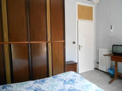 a bedroom with a wooden cabinet and a bed at Casa di Roma in Rome