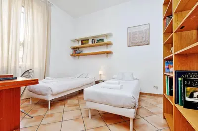 a living room with two beds and a book shelf at Romalibera in Rome