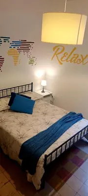 a bedroom with a bed with a blue blanket on it at Apartment Ostiense Piramide Station in Rome