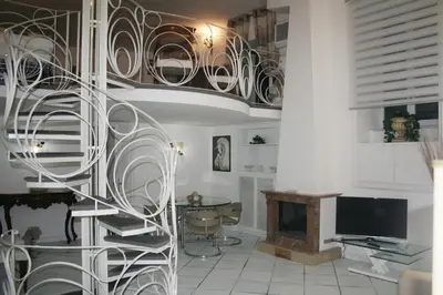 a spiral staircase in a living room with a desk at Foro Romano Apartments A in Rome